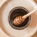 Top view of honey dipper in a jar, perfect for culinary and food themes.